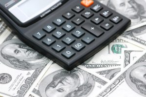 accounting calculator over the hundred dollar bank notes